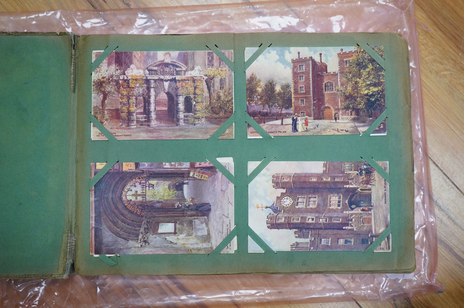 A postcard album with various postcards. Condition - damp damage